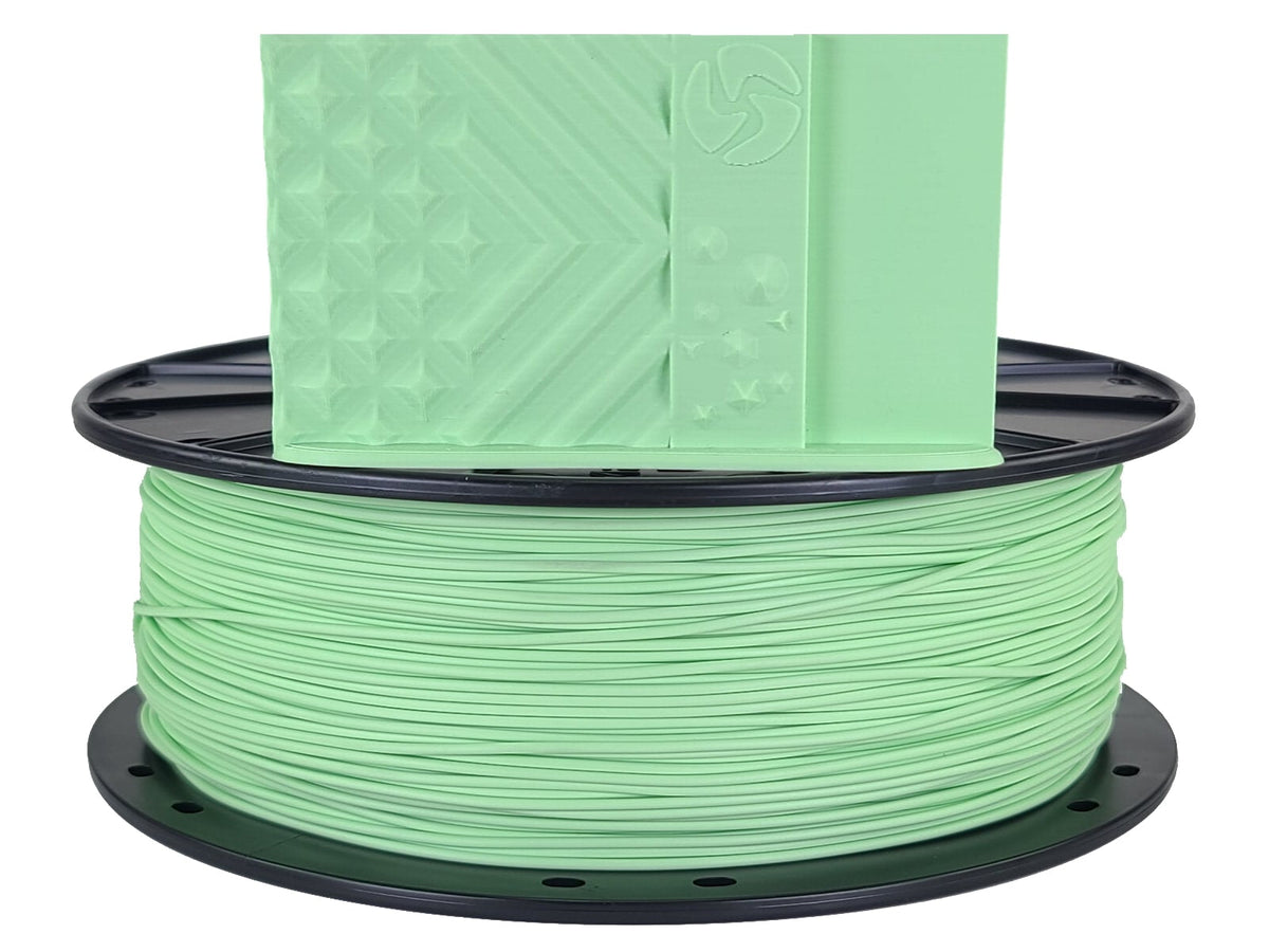 Spool of green filament on a white background
