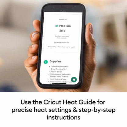 A hand holds a smartphone showing the Cricut app with heat settings and supplies, with the text 'Use the Cricut Heat Guide for precise heat settings & step-by-step instructions' below.