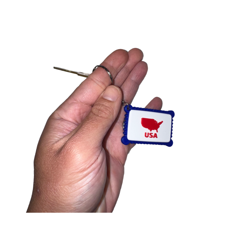 Hand holding a keychain with a USA map design on a white background