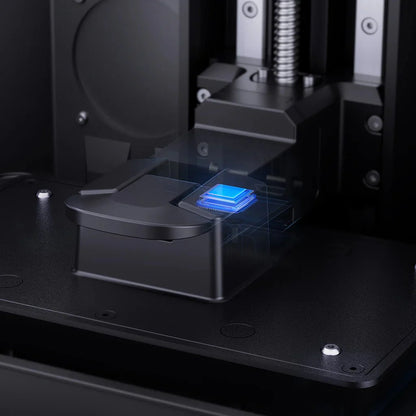 3D printer in operation with a blue light on the print bed