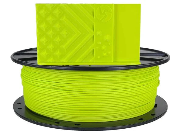 Spool of bright green filament on a black spool with a white background