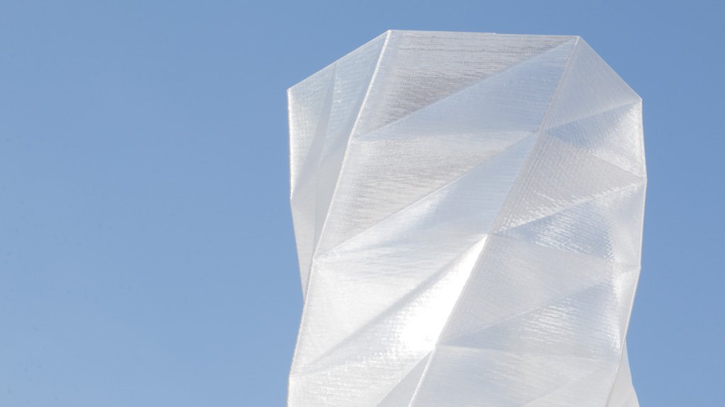 White geometric sculpture against a clear blue sky