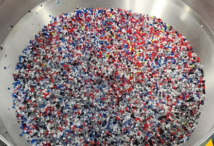 Colorful plastic pellets in a metal container