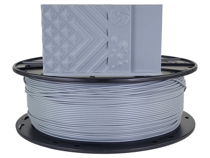 Spool of gray filament with a 3D printer nozzle on a white background